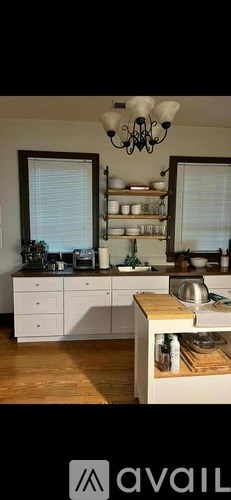 A kitchen with white cabinets and a wooden island.