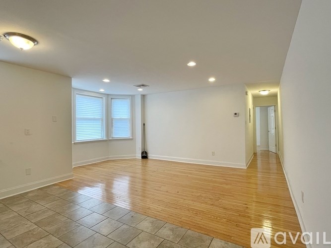 A room with wooden flooring and white walls is available for rent.