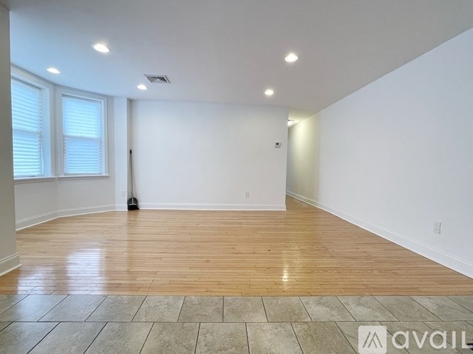 A room with wooden flooring and white walls is available for rent.
