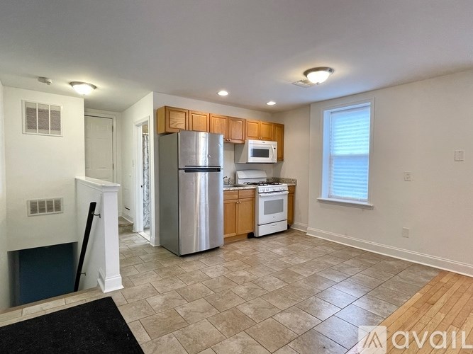 A kitchen with a refrigerator, stove, and microwave.