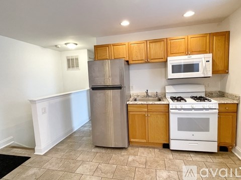 A kitchen with wooden cabinets and a white stove top oven.