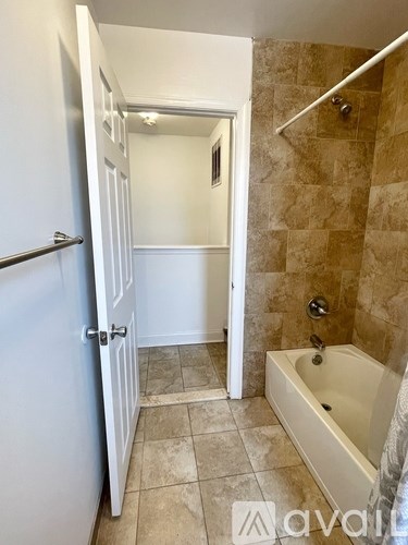 A bathroom with a tub and a toilet.
