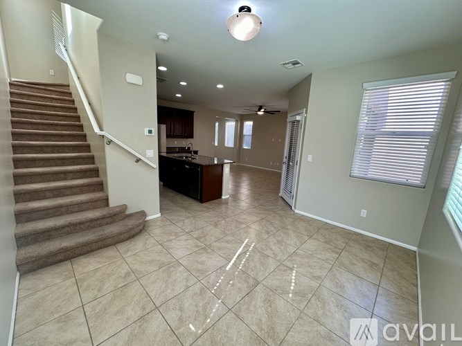 A spacious living room with a staircase on the left side.