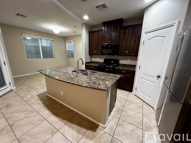 A kitchen with granite countertops and tile flooring.