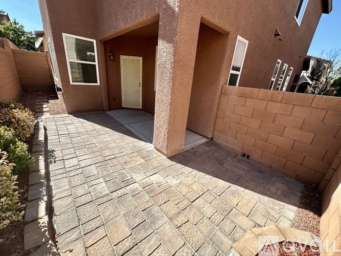 A house with a brown door and a brick wall.