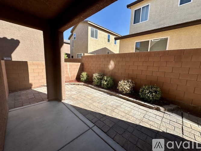 A patio area with a brick wall and a tiled floor.
