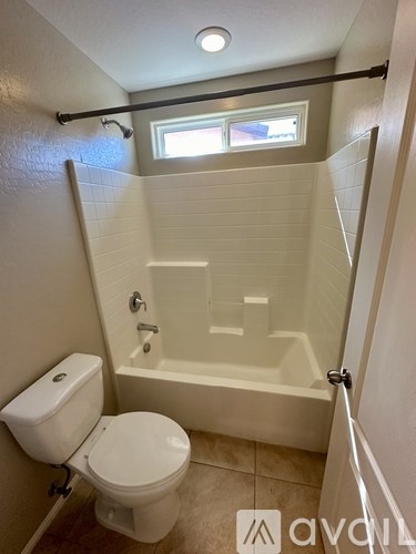 A white toilet sits next to a bathtub in a bathroom.
