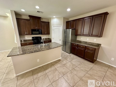 A kitchen with brown cabinets and a granite countertop.