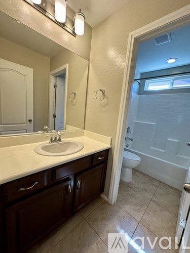 A bathroom with a sink, mirror, and toilet.