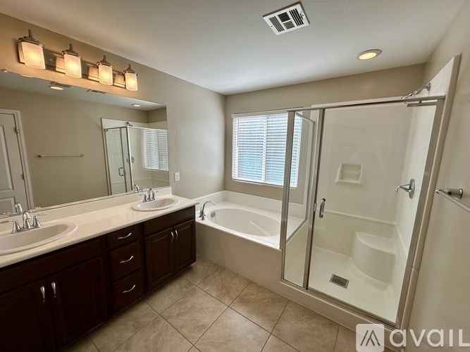 A bathroom with a tub, sink, and mirror.