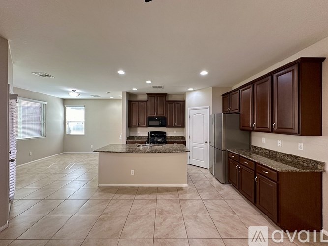 A spacious kitchen with brown cabinets and a marble countertop.