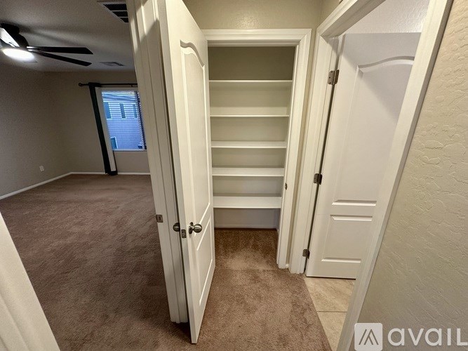 A room with a white door and a carpeted floor.