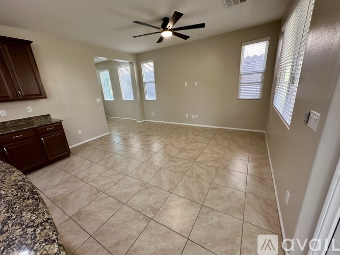 A spacious room with a ceiling fan and tiled flooring.