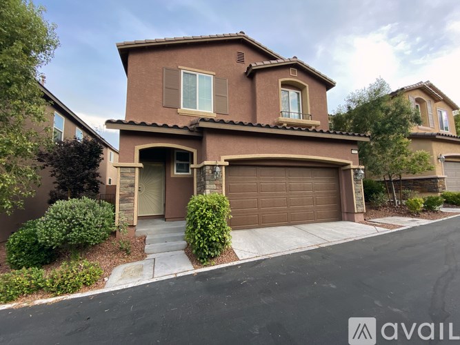 A house with a brown exterior and a garage door is for sale.