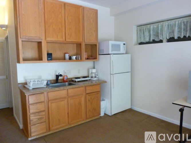 A kitchen with wooden cabinets and a white fridge.