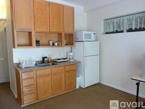 A kitchen with wooden cabinets and a white fridge.
