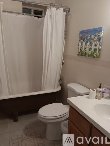 A bathroom with a toilet, sink, and shower.
