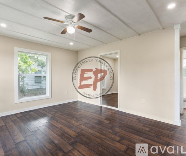 A room with wooden floors and a ceiling fan.