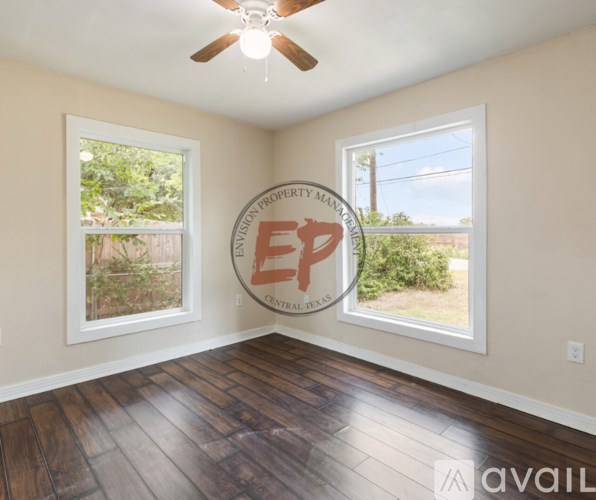 A room with a logo on the wall and a window showing greenery outside.