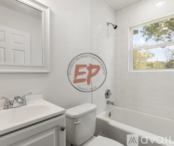 A white bathroom with a toilet, sink, and tub.