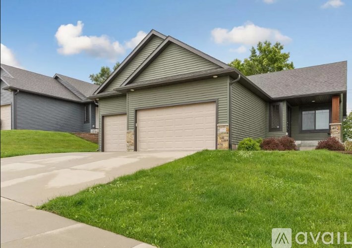A house with a garage and a driveway in front.