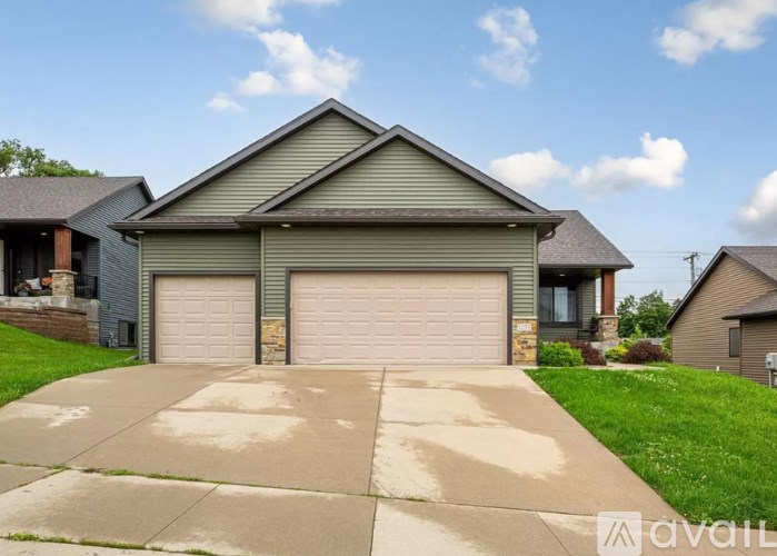 A house with a grey roof and two garages.