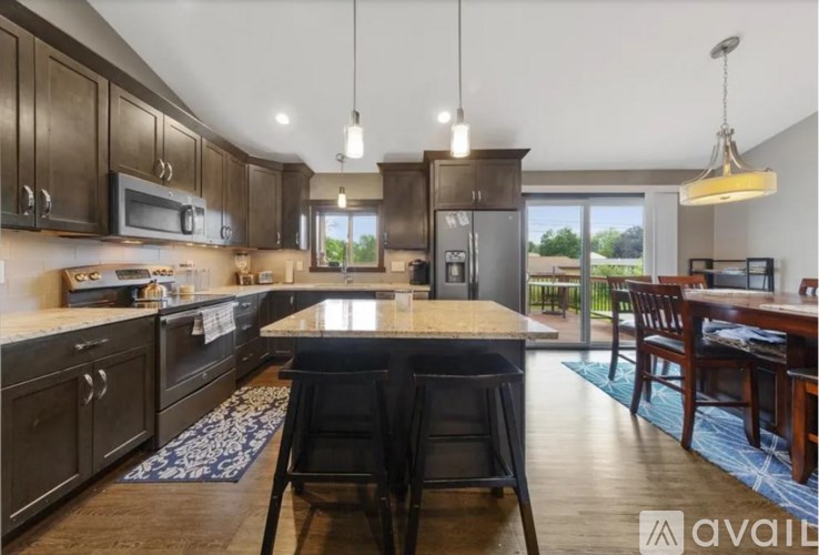 A kitchen with dark wood cabinets and a large island in the middle.