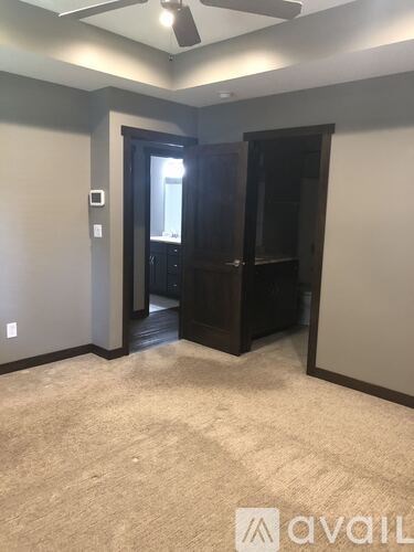 A room with a carpeted floor and a ceiling fan.