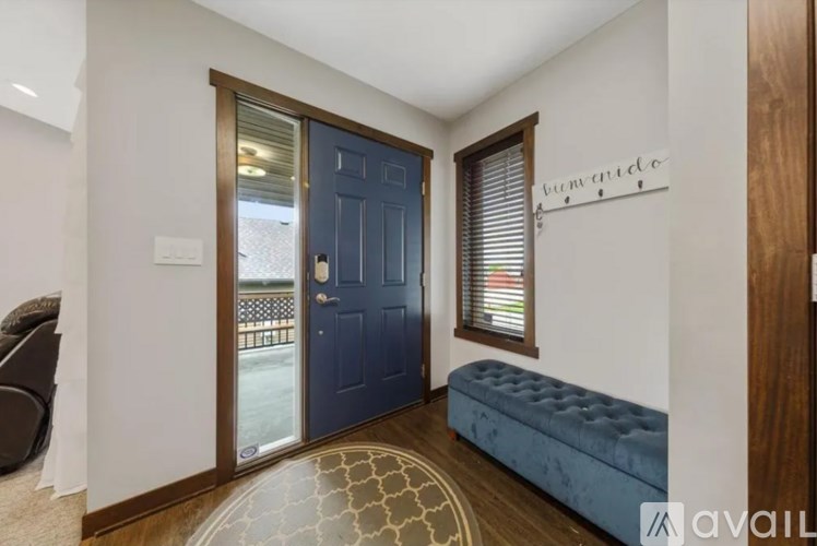 A room with a blue door and a bench.