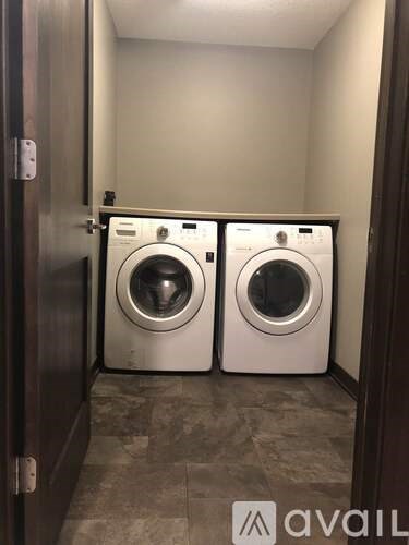 Two front loading washing machines in a small laundry room.