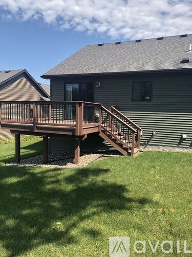 A deck with stairs leading to a house.