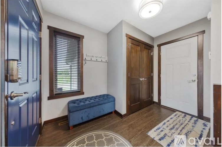 A hallway with a blue bench and a white door.