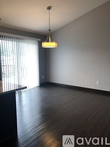 A room with wooden floors and a hanging light fixture.