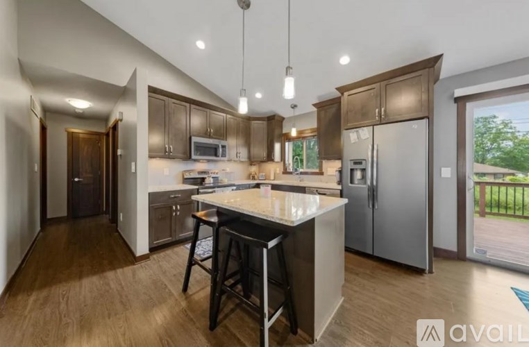A kitchen with a center island and a refrigerator to the right.