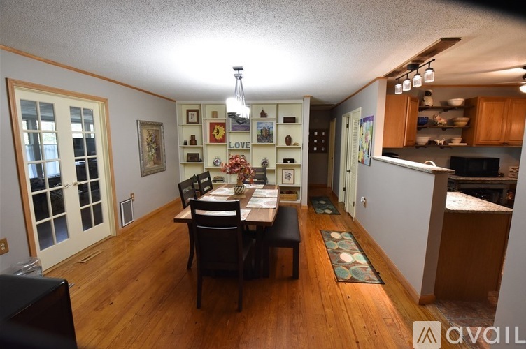 A dining room with a wooden table and chairs.