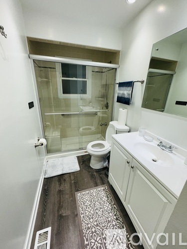 A bathroom with a toilet, sink, and shower.