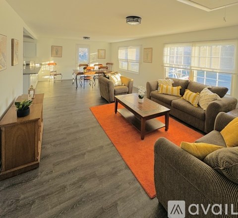 A living room with a grey couch and a wooden cabinet.