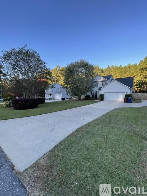 A white house with a driveway in front of it.