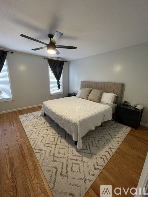 A bedroom with a large bed and a ceiling fan.