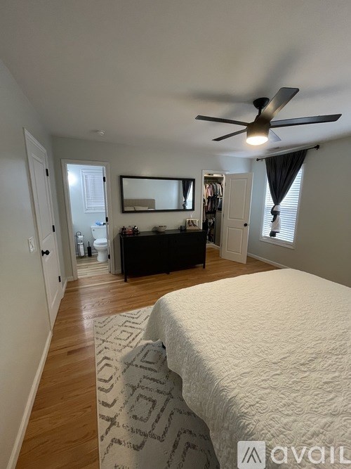 A bedroom with a bed, dresser, and mirror.