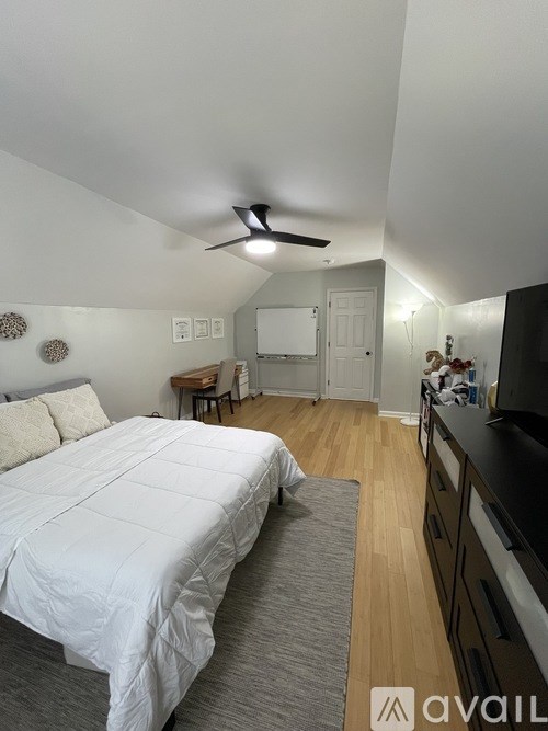 A bedroom with a large bed and a ceiling fan.