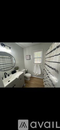 A bathroom with a toilet, sink, and a window.