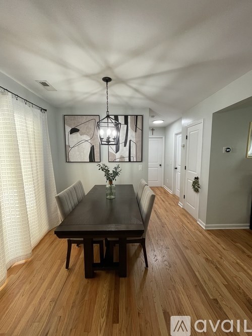 A dining room with a wooden table and chairs.