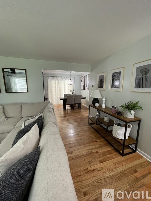 A living room with a couch, a table, and a plant.
