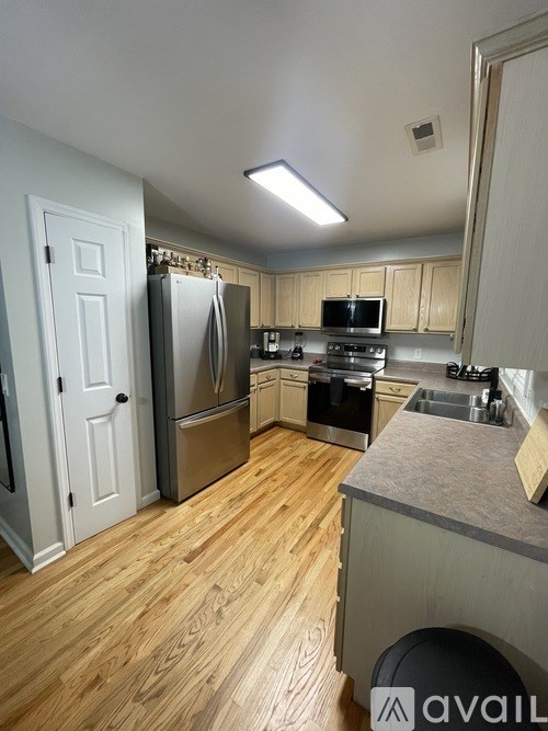 A kitchen with wooden floors and stainless steel appliances.