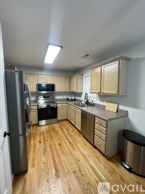 A kitchen with wooden floors and stainless steel appliances.