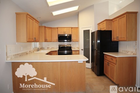 A kitchen with wooden cabinets and a Morehouse Property Management logo on the island.