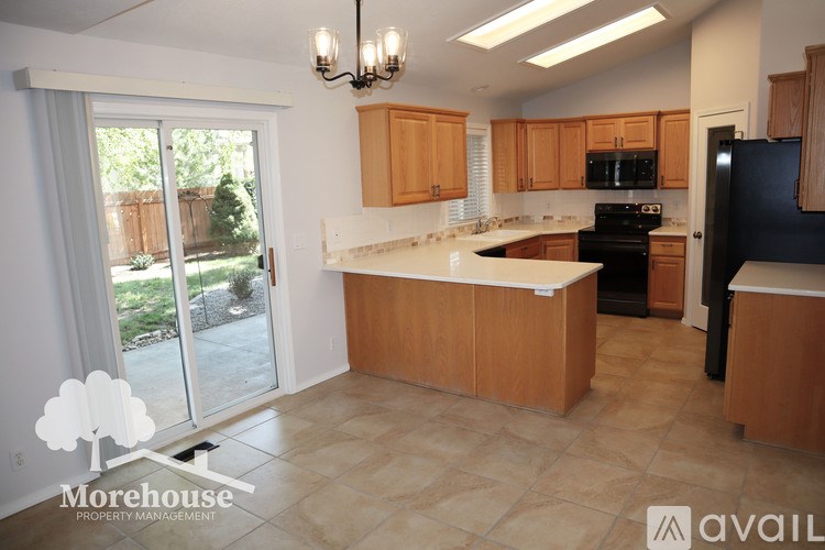 A kitchen with wooden cabinets and a black refrigerator.