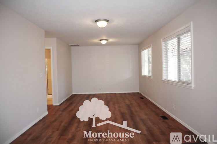 A room with a logo of a tree and the text "Morehouse Property Management" on the floor.