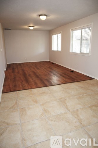 A room with wooden floors and tiled flooring in the foreground.